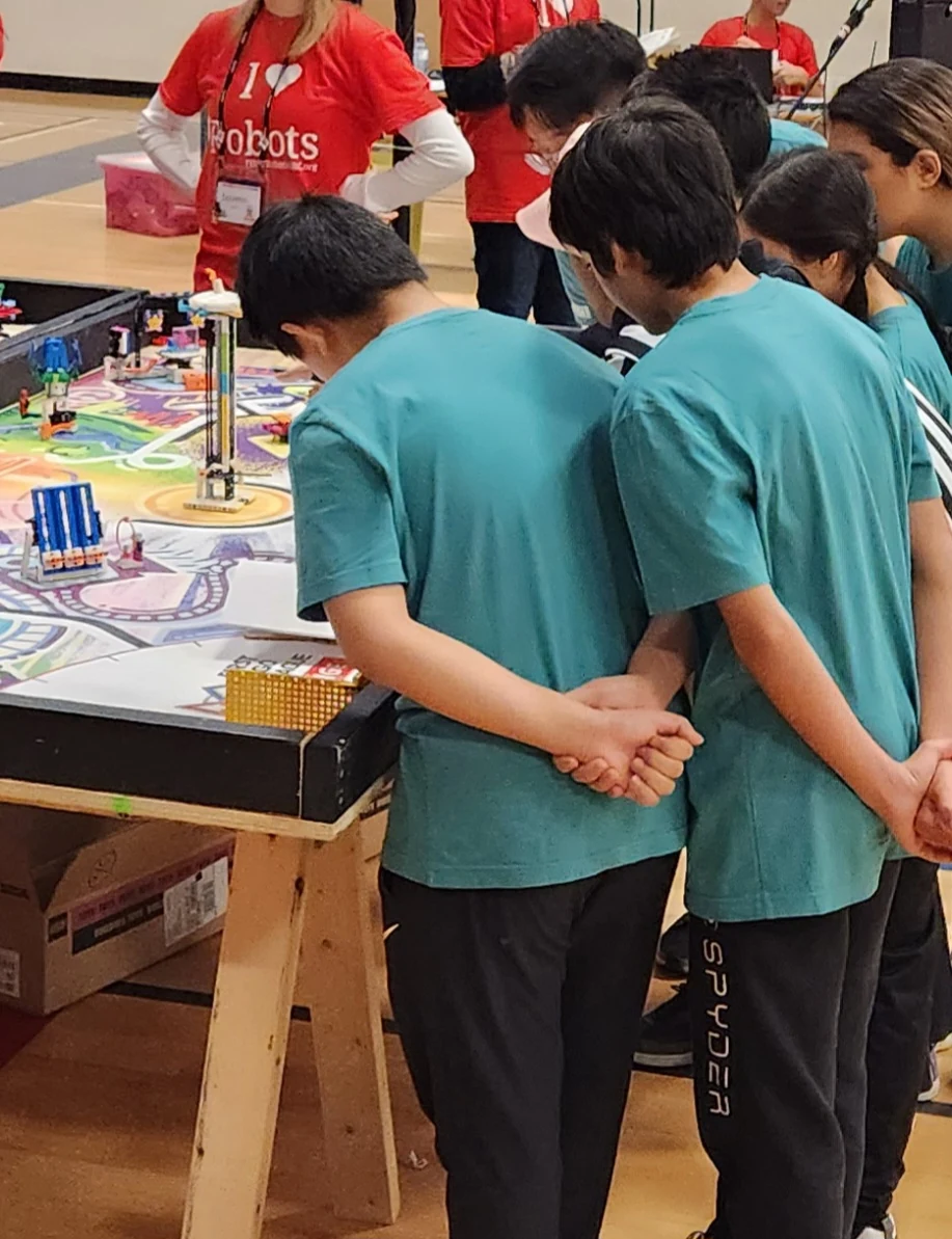FIRST LEGO League students working together at a competition table